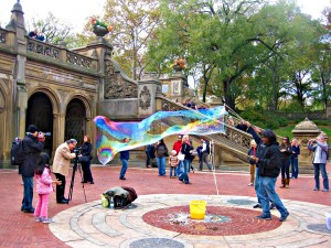 An entertainer blows massive bubbles in New York City's Central Park