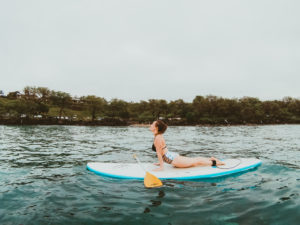 Attempting SUP yoga on a stand up paddle boarding tour with Maui SUP