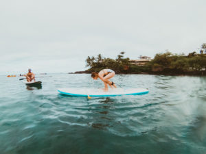 Attempting SUP yoga on a stand up paddle boarding tour with Maui SUP