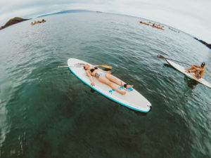 Attempting SUP yoga on a stand up paddle boarding tour with Maui SUP